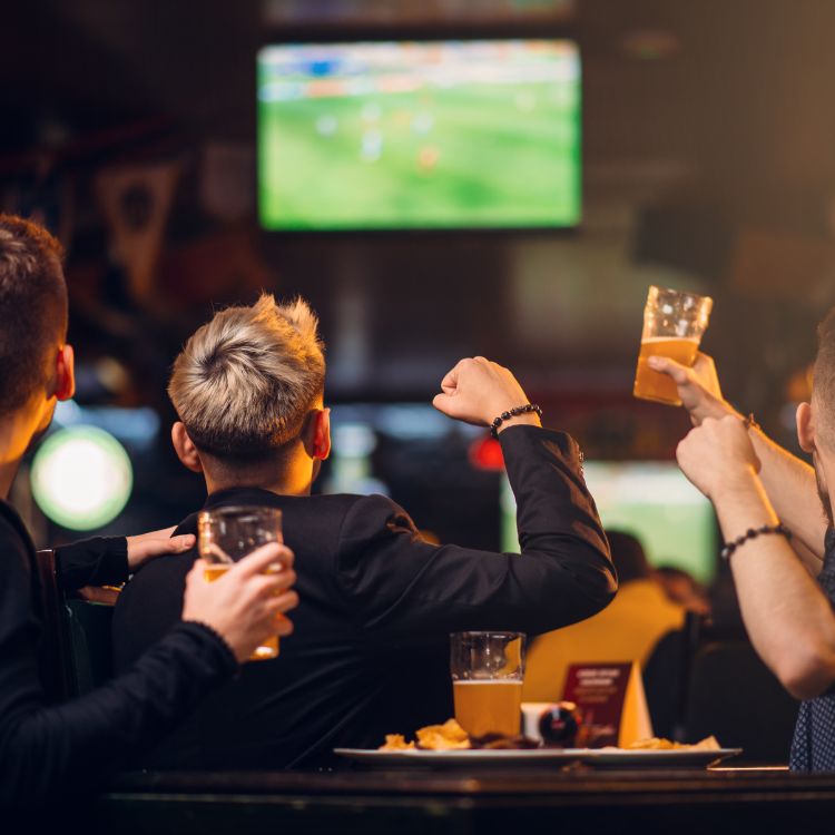 People cheering for their favourite team as they watch their sports at The Pint Vancouver.